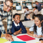 teacher with 4 students in the table smiling